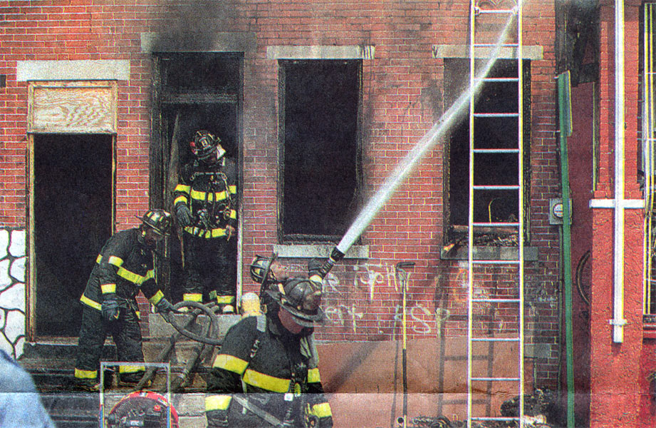 Firefighters battle the blaze at 1442 Rose Street; EMT Pat Kessler tends to boarder Ace Jackson