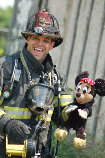 Fire fighter Javier Matos of Ladder Company 3 holding Minnie Mouse after reviving her from the blaze at 528 Borton Street, June 1, 2008