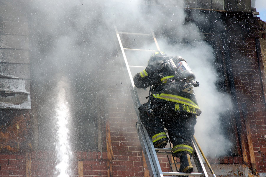 Ladder Company 1 fire fighter Mariano Pinto ascending ladder for ventilation and overhaul at 528 Borton Street fire, June 1, 2008