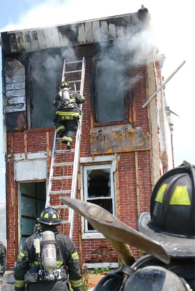 Ladder Company 1 fire fighter Mariano Pinto ascending ladder at 528 Borton Street fire, June 1, 2008