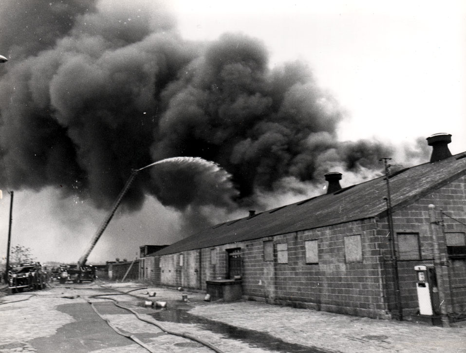 Ladder Company 3 gets water on fire at the former John R. Evans Leather Company, December 19, 1971. Firefighter Thomas J. DiBiaso operating the ladder nozzle. Photo by Bob Bartosz.
