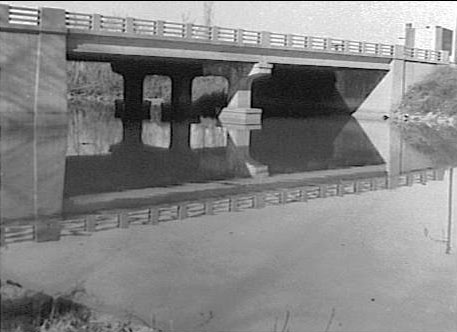 Looking northwest at Baird Avenue Bridge from Farnham Park with Oasis Motel visible, March 1960, photo by Louis Morris