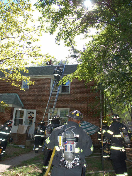 547 Pfeiffer Street fire — firefighters helping man onto ladder