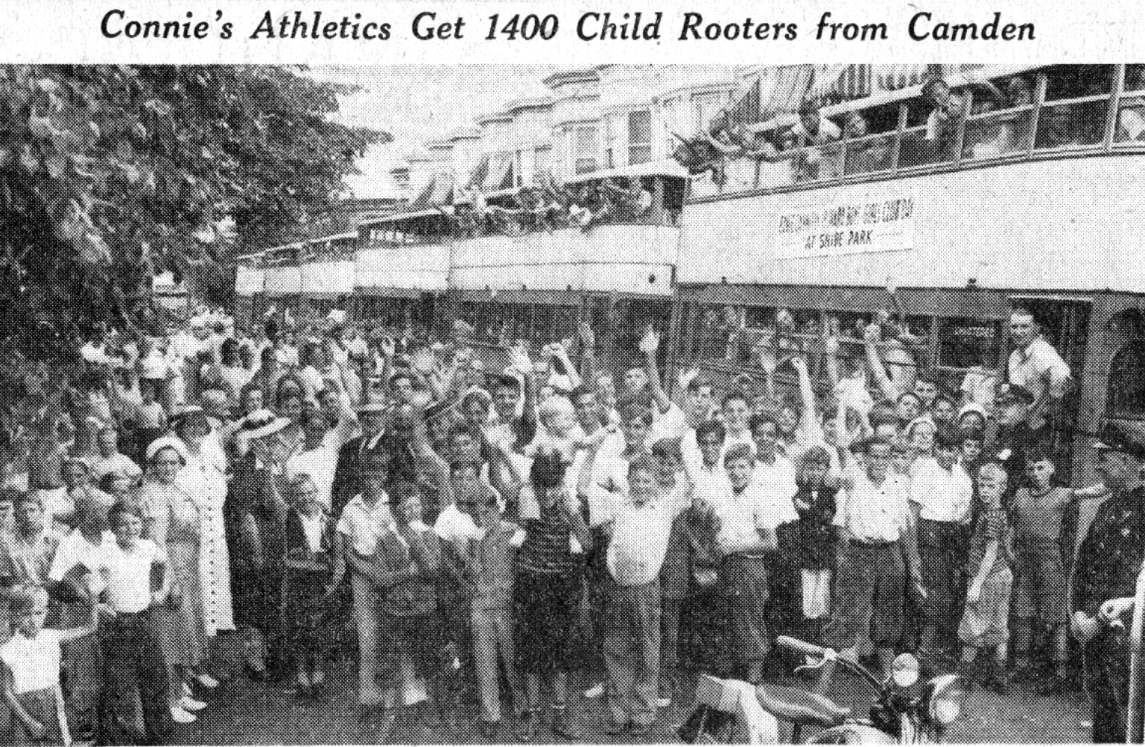 Newspaper photo of hundreds of Camden children waving beside a line of buses bound for Shibe Park, July 1941.
